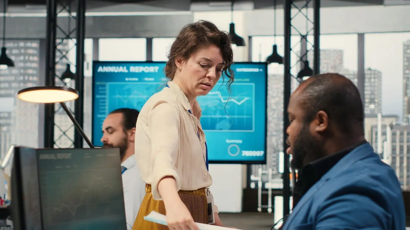 Una secretaria en una oficina empuja un carrito repleto de documentos.