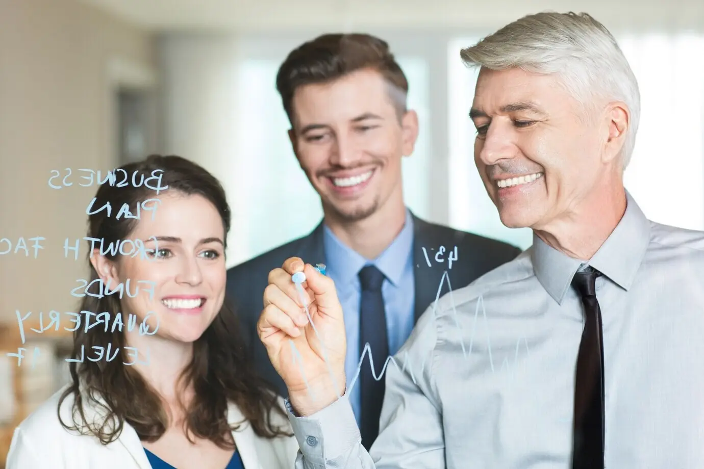 Jefe feliz que dibuja un gráfico y capacita a sus colegas.